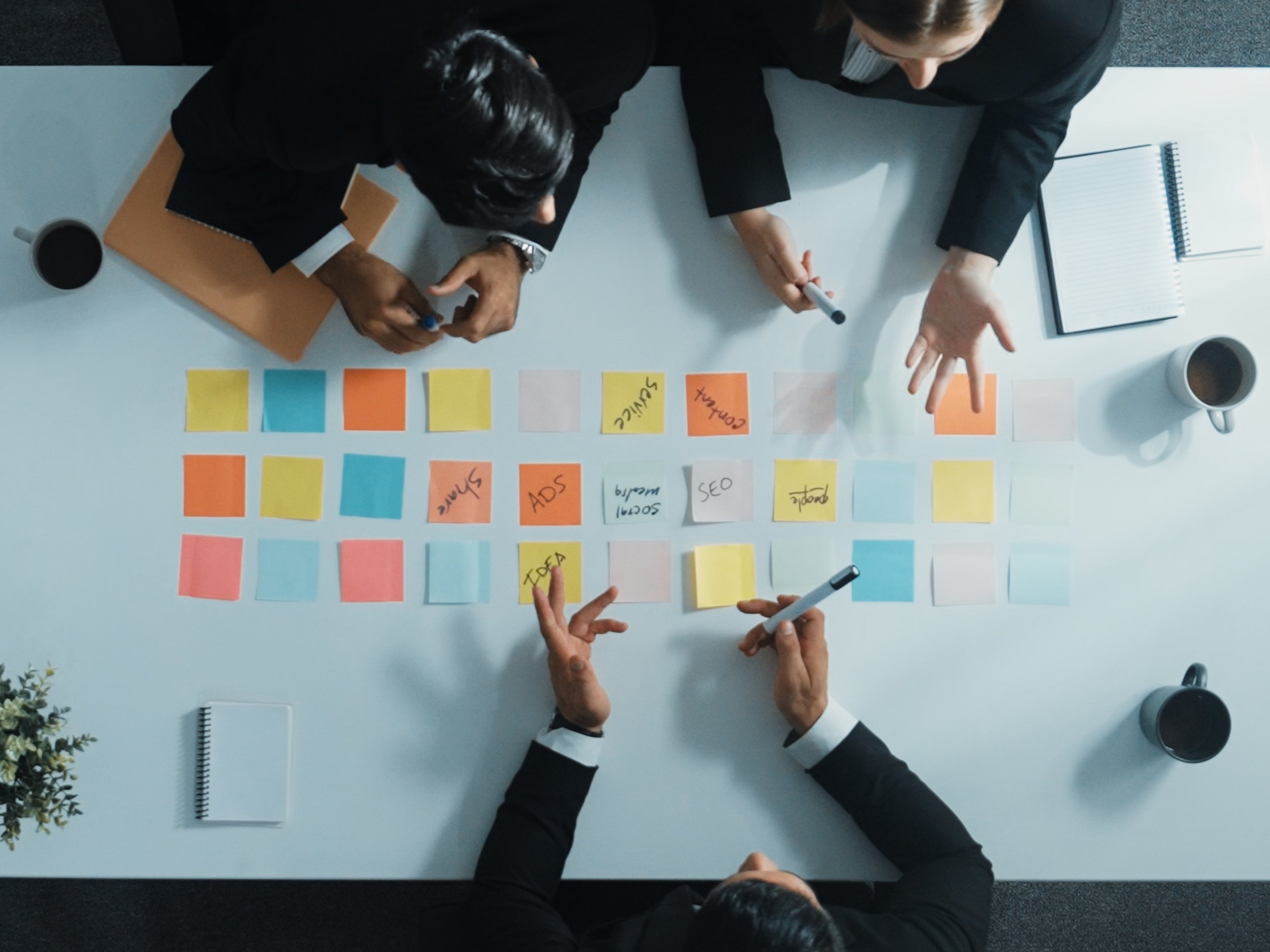 amadeus Leistung 6 Ein Team von amadeus plant gemeinsam eine Kommunikationsstrategie mit farbigen Haftnotizen und strukturiert Themen wie SEO Social Media Service und Ads im Rahmen der Leistungsbereiche Konzeption Kampagne und Content